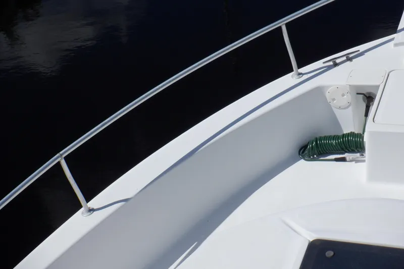 Slide: The Image of 1999 Mainship 350 Trawler deck with railing and coiled green hose. - 12