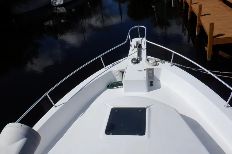Slide: The Image of 1999 Mainship 350 Trawler bow view, docked on calm water. - 13