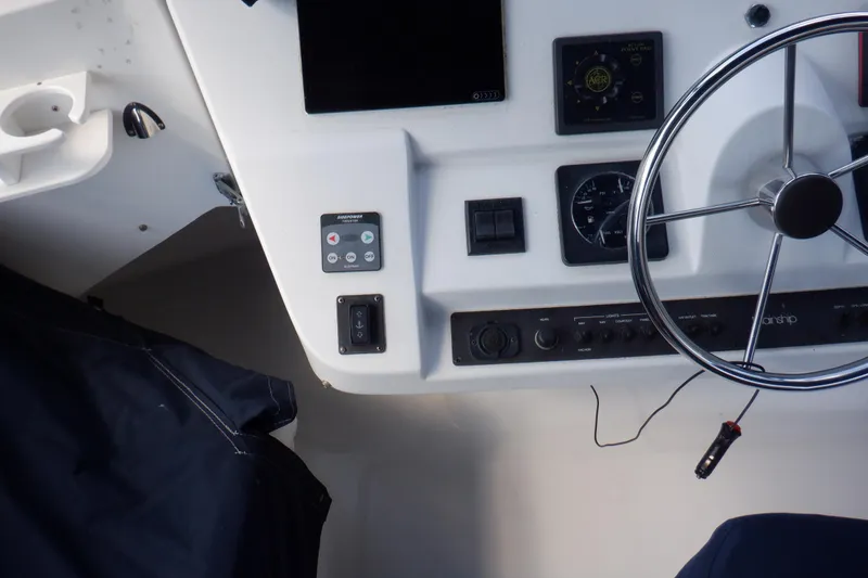 Slide: The Image of 1999 Mainship 350 Trawler helm with steering wheel and control panel. - 22