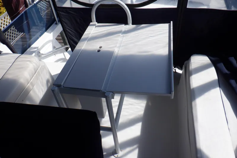Slide: The Image of 1999 Mainship 350 Trawler interior with foldable table and cushioned seating. - 25