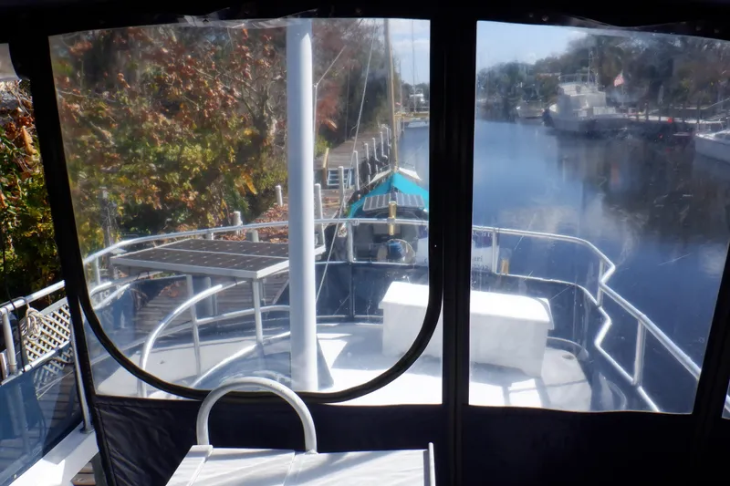 Slide: The Image of 1999 Mainship 350 Trawler on a serene river, surrounded by autumn foliage. - 26