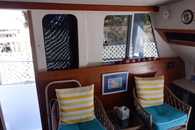 Slide: The Image of Interior of 1999 Mainship 350 Trawler with wicker chairs and striped cushions. - 32