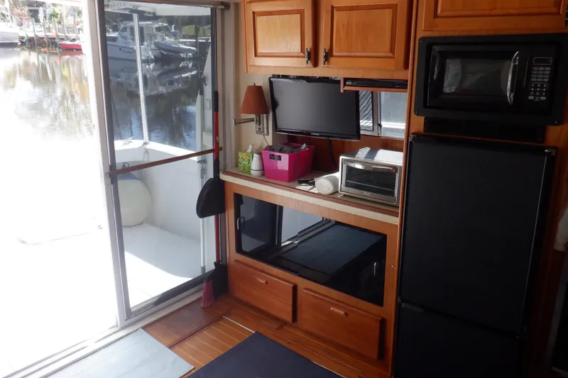 Slide: The Image of 1999 Mainship 350 Trawler interior with kitchen appliances and sliding door to deck. - 36