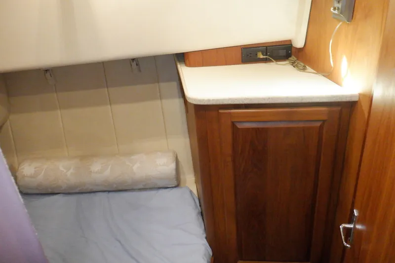 Slide: The Image of 1999 Mainship 350 Trawler cabin interior with wooden cabinetry and cozy sleeping area. - 39