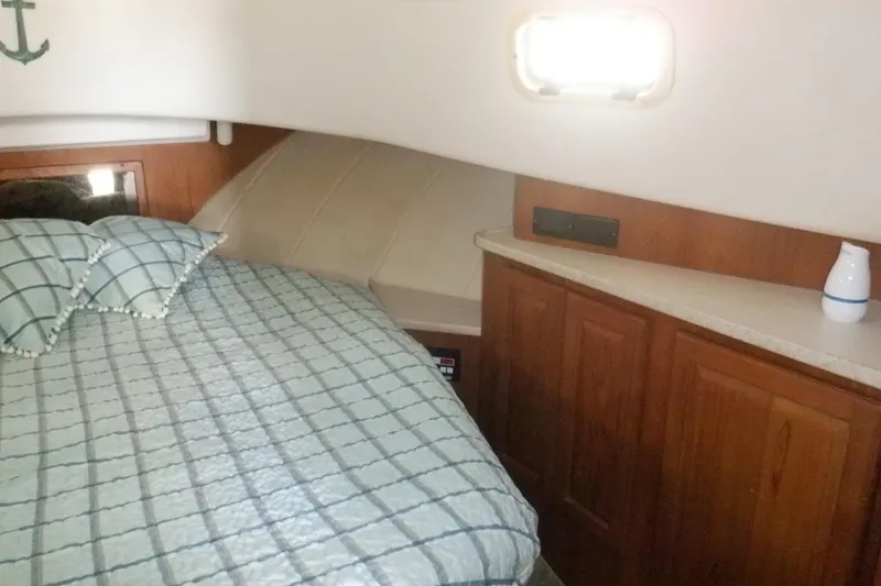Slide: The Image of Cozy cabin interior of 1999 Mainship 350 Trawler with bed and wooden cabinetry. - 44