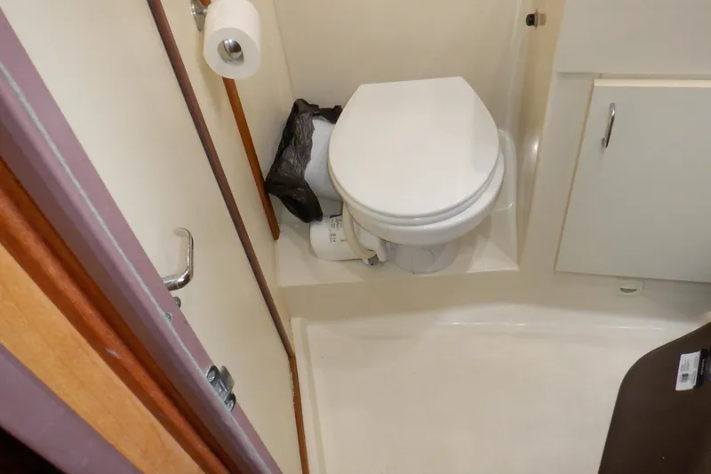 Slide: The Image of Bathroom interior of 1999 Mainship 350 Trawler with toilet and storage cabinet. - 45