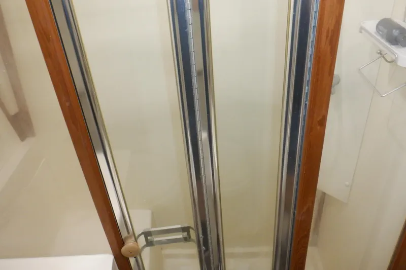 Slide: The Image of Shower area inside 1999 Mainship 350 Trawler with glass door and wooden frame. - 47