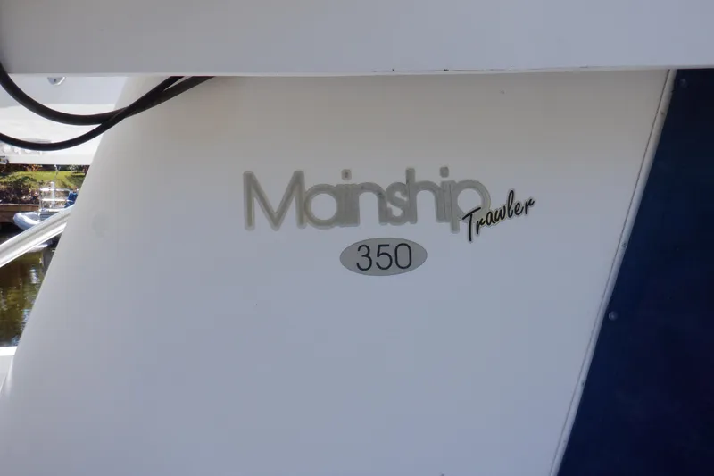 Slide: The Image of 1999 Mainship 350 Trawler boat logo on white hull. - 5