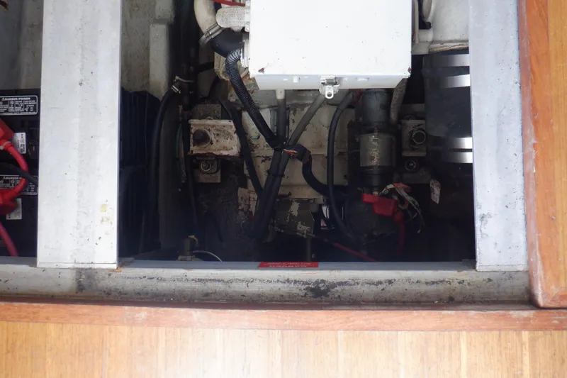 Slide: The Image of Engine compartment of a 1999 Mainship 350 Trawler, showing wiring and mechanical components. - 52