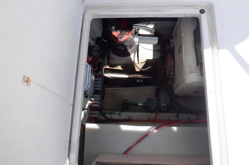 Slide: The Image of Engine compartment of a 1999 Mainship 350 Trawler, showing mechanical components and wiring. - 55