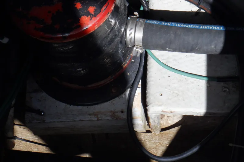 Slide: The Image of Engine compartment of a 1999 Mainship 350 Trawler with exhaust hose and clamps. - 56