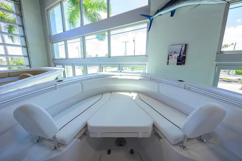 Slide: The Image of 2026 Sportsman Open 252 Center Console boat interior with white seating in a showroom. - 11