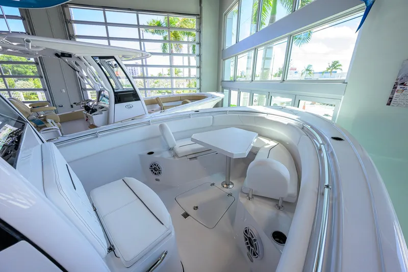 Slide: The Image of 2026 Sportsman Open 252 Center Console boat interior with seating and table in showroom. - 21