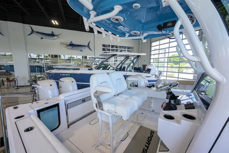 Slide: The Image of 2026 Sportsman Open 252 Center Console boat interior in showroom, featuring modern seating and controls. - 23