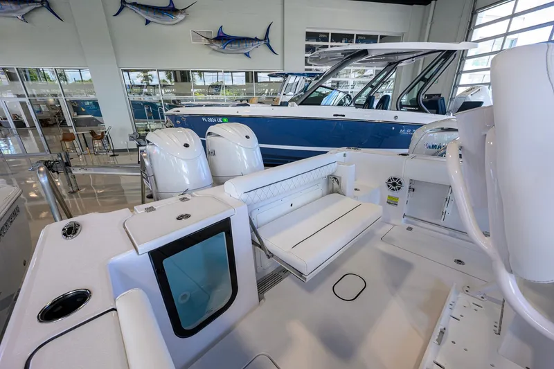 Slide: The Image of 2026 Sportsman Open 252 Center Console boat interior in showroom, featuring dual engines. - 26