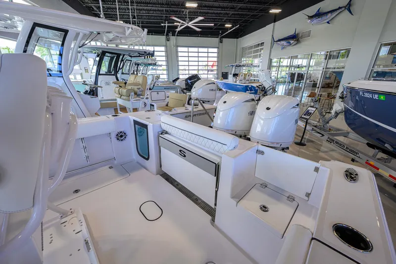 Slide: The Image of 2026 Sportsman Open 252 Center Console boat displayed in a showroom with other boats. - 29