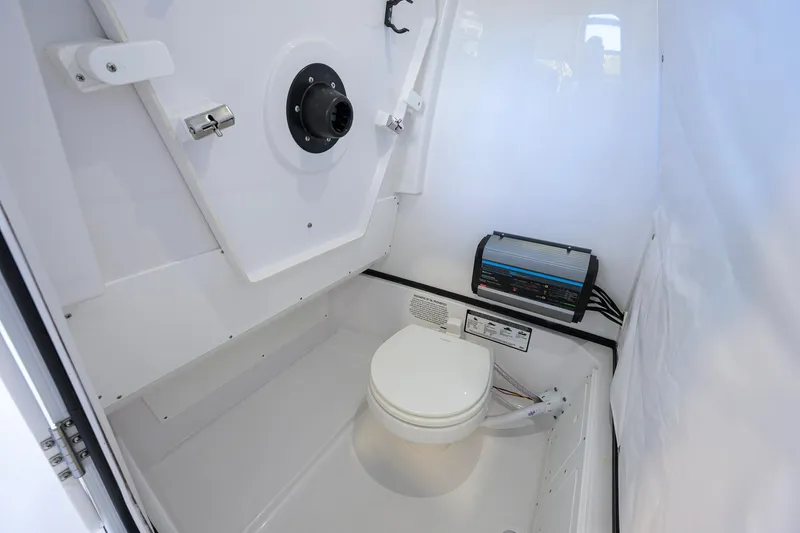 Slide: The Image of Interior of 2026 Sportsman Open 252 Center Console boat, featuring a compact marine toilet. - 42