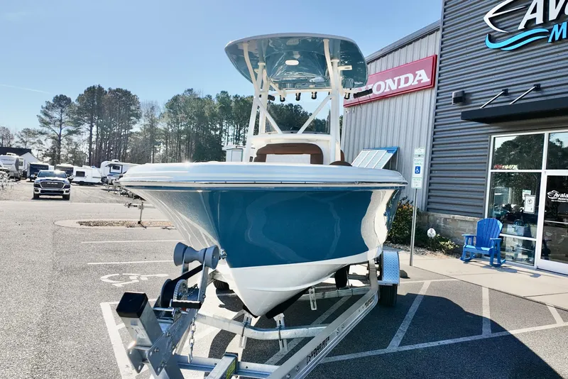 Slide: The Image of 2026 Pioneer 202 Islander boat on trailer outside dealership, sunny day. - 19
