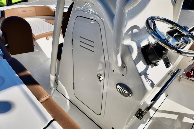 Slide: The Image of 2026 Pioneer 202 Islander boat interior with steering wheel and seating area. - 8