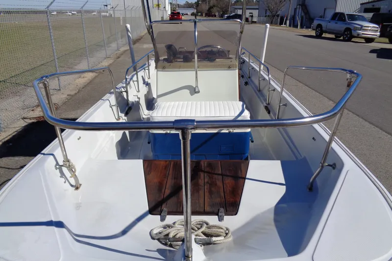 Slide: The Image of 1987 Boston Whaler Montauk 17' CC boat, docked, with stainless steel railings and seating. - 11