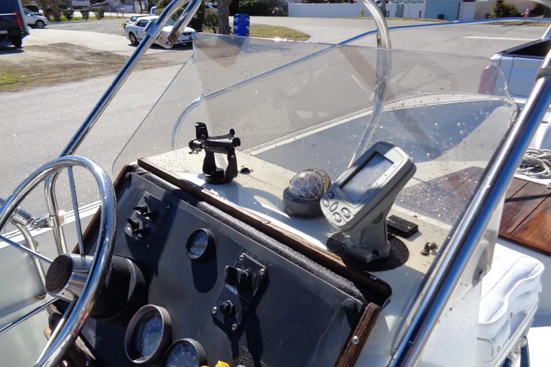 Slide: The Image of 1987 Boston Whaler Montauk 17' CC dashboard with steering wheel and navigation instruments. - 15
