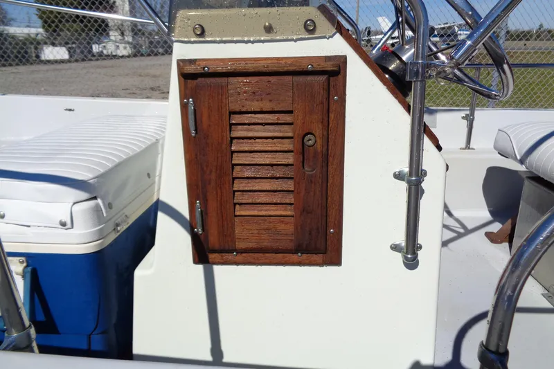 Slide: The Image of 1987 Boston Whaler Montauk 17' CC console with wooden storage compartment and steering wheel. - 10