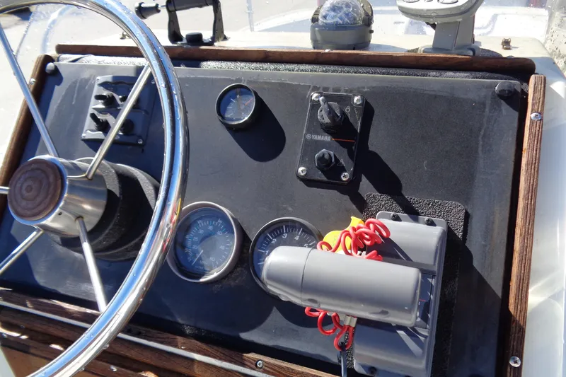 Slide: The Image of 1987 Boston Whaler Montauk 17' CC dashboard with steering wheel and gauges. - 14