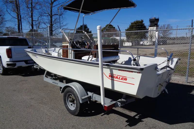 Slide: The Image of 1987 Boston Whaler Montauk 17' CC boat on trailer, parked outdoors. - 2
