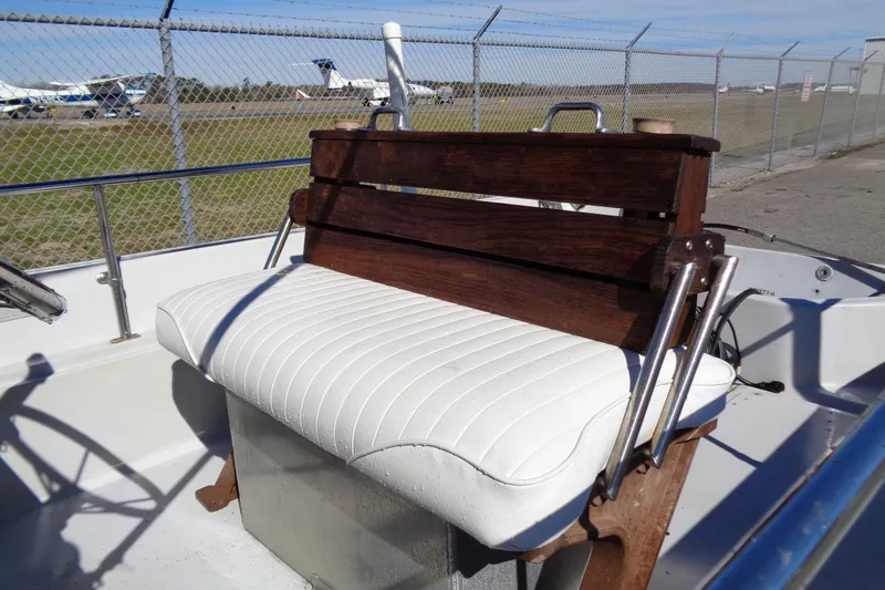 Slide: The Image of 1987 Boston Whaler Montauk 17' CC boat interior with white cushioned seating. - 6