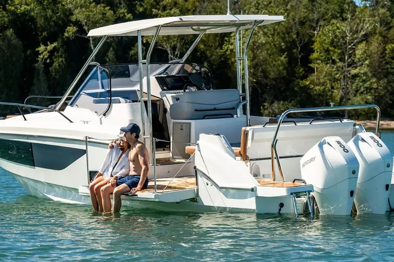 Slide: The Image of 2023 Beneteau Flyer 9 SUNdeck with two people relaxing on the deck in a scenic setting. - 26