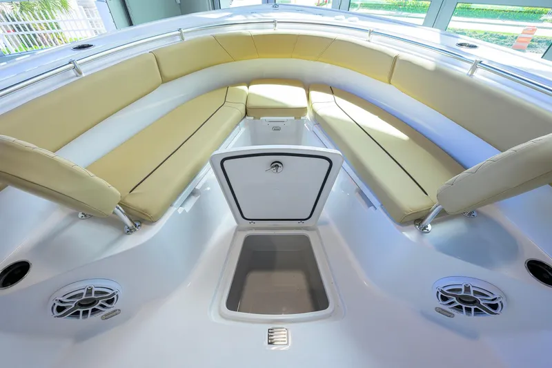 Slide: The Image of 2026 Sportsman Open 232 Center Console boat interior with beige seating and storage compartment. - 14