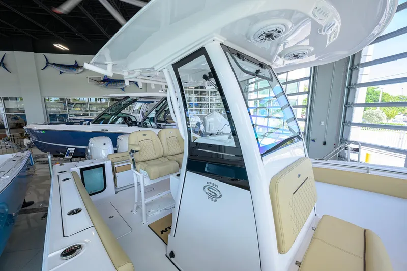 Slide: The Image of 2026 Sportsman Open 232 Center Console boat interior in showroom, featuring beige seating and modern design. - 21