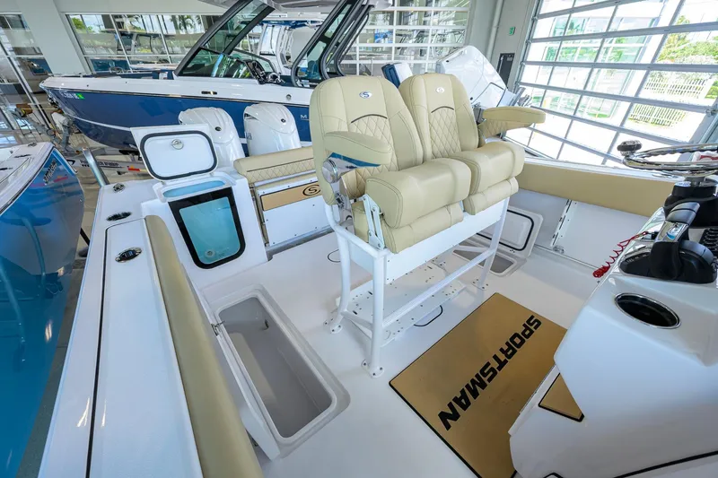 Slide: The Image of 2026 Sportsman Open 232 Center Console boat interior with beige seating and storage compartments. - 23