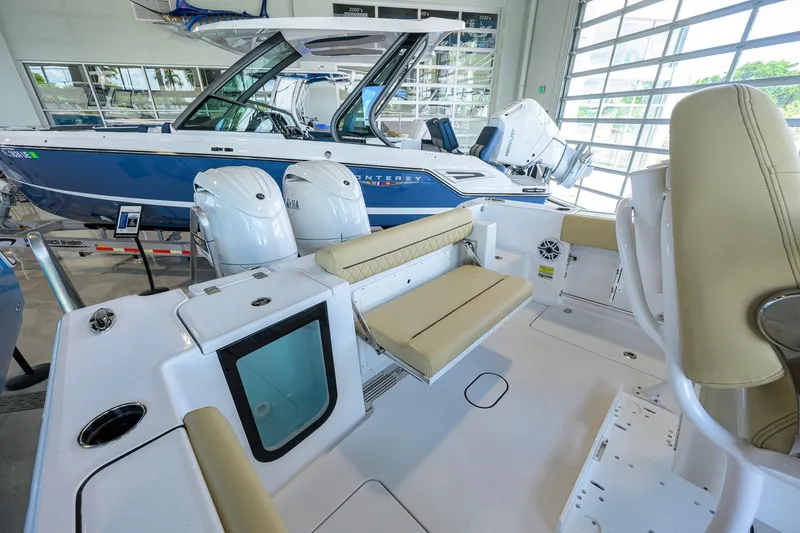 Slide: The Image of 2026 Sportsman Open 232 Center Console boat interior with seating and dual engines in showroom. - 25