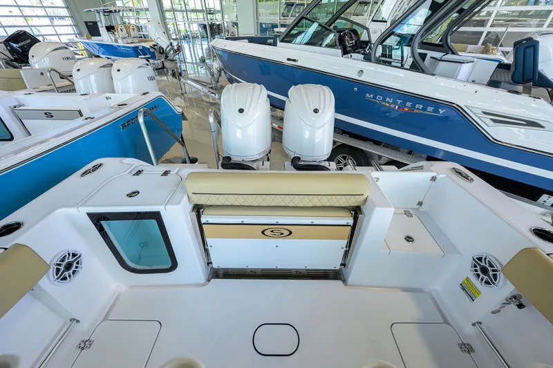 Slide: The Image of 2026 Sportsman Open 232 Center Console boat interior with dual engines in showroom. - 26