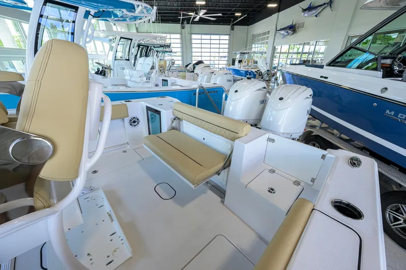 Slide: The Image of 2026 Sportsman Open 232 Center Console boat interior with seating and Yamaha engines in showroom. - 32