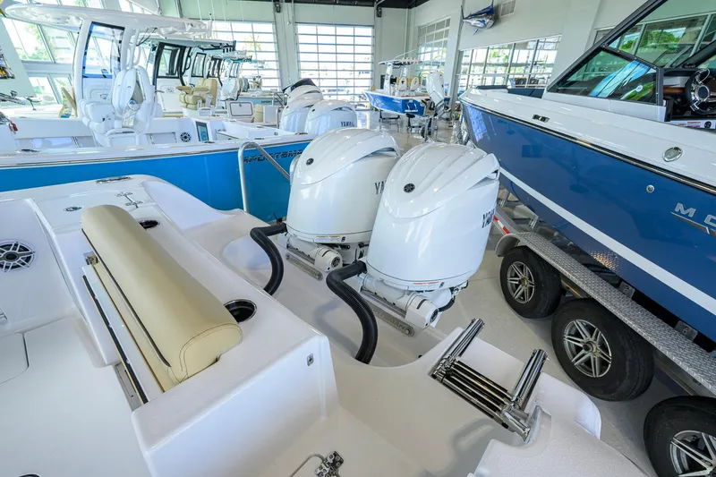 Slide: The Image of 2026 Sportsman Open 232 Center Console boat with dual Yamaha outboard engines in showroom. - 33