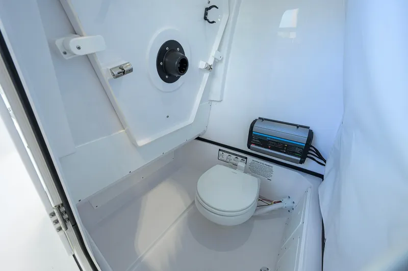 Slide: The Image of 2026 Sportsman Open 232 Center Console boat interior with marine toilet and control panel. - 41