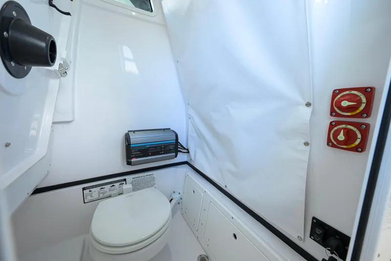 Slide: The Image of Interior of 2026 Sportsman Open 232 Center Console boat with marine toilet and controls. - 42