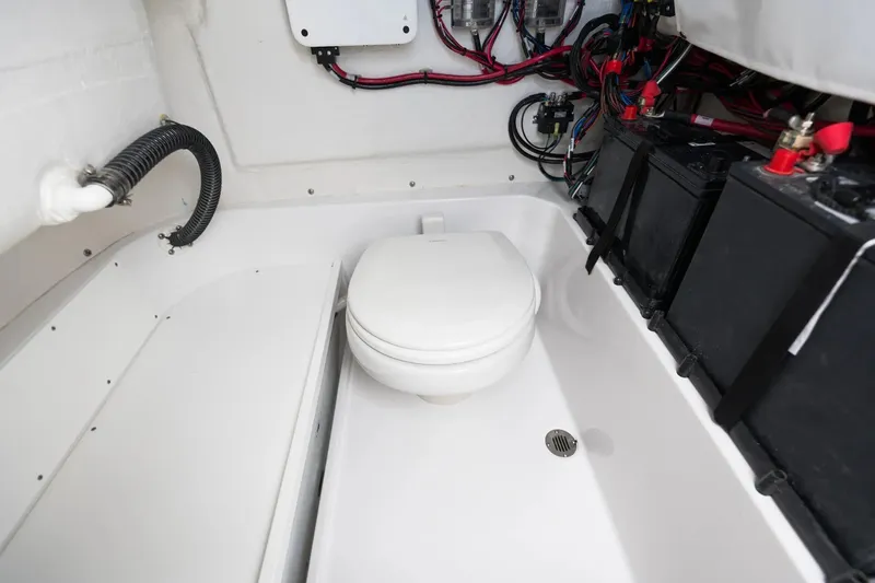 Slide: The Image of 2026 Sportsman Open 232 Center Console boat interior with toilet and wiring. - 6