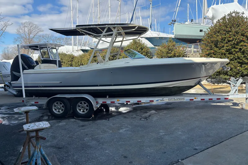 The Image of 2017 Chris-Craft Calypso 26 boat on trailer, parked outdoors with other boats. - 0