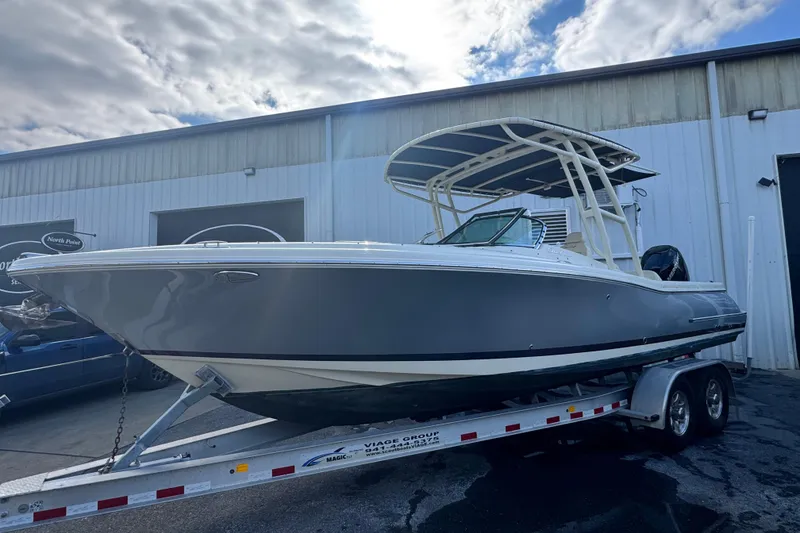 Slide: The Image of 2017 Chris-Craft Calypso 26 boat on trailer, parked outside a warehouse. - 1