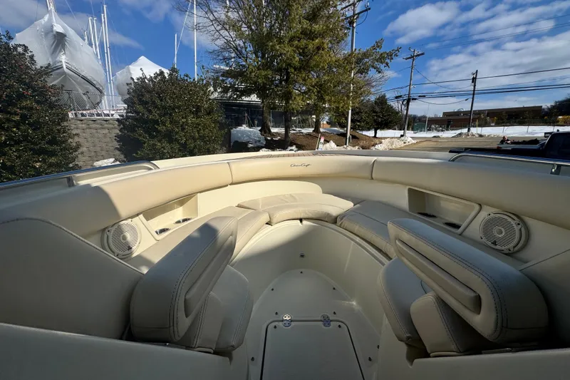 Slide: The Image of 2017 Chris-Craft Calypso 26 boat interior with beige seating and speakers. - 13