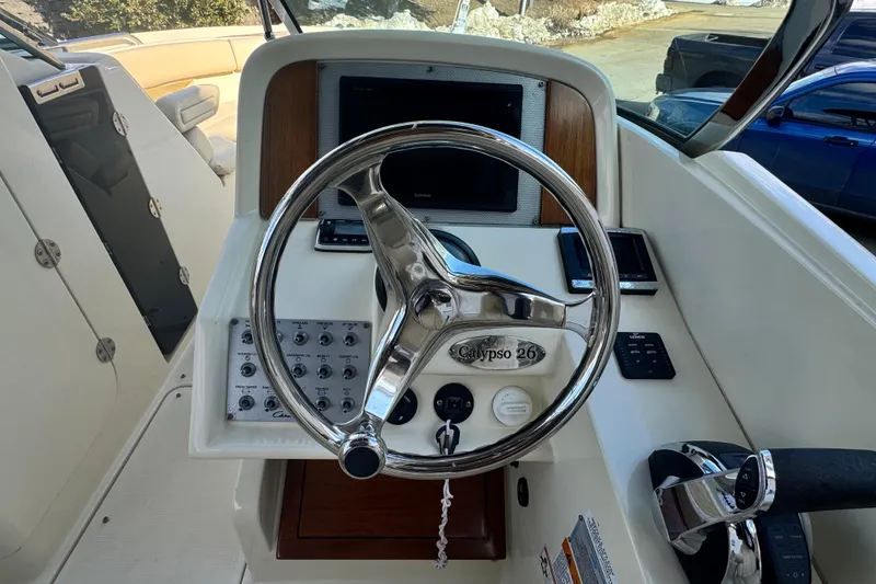 Slide: The Image of 2017 Chris-Craft Calypso 26 boat helm with steering wheel and control panel. - 16