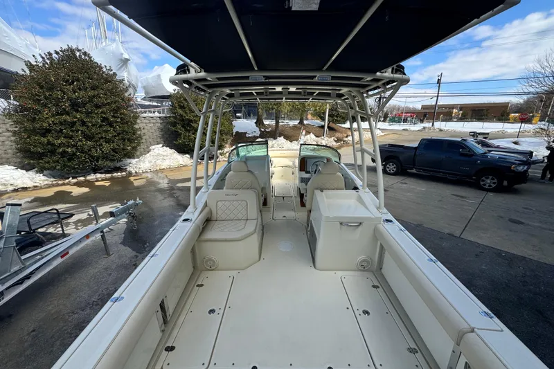 Slide: The Image of 2017 Chris-Craft Calypso 26 boat interior with seating and storage, parked outdoors. - 21