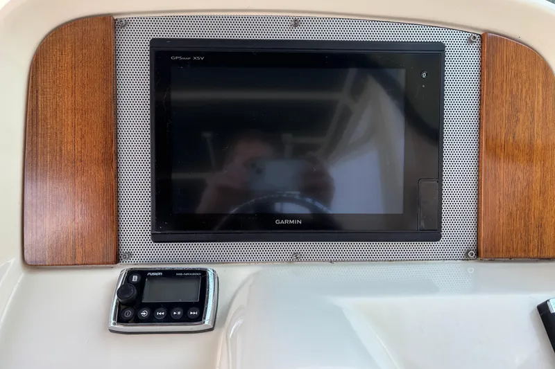 Slide: The Image of Dashboard of 2017 Chris-Craft Calypso 26 with Garmin GPS and Fusion audio controls. - 26