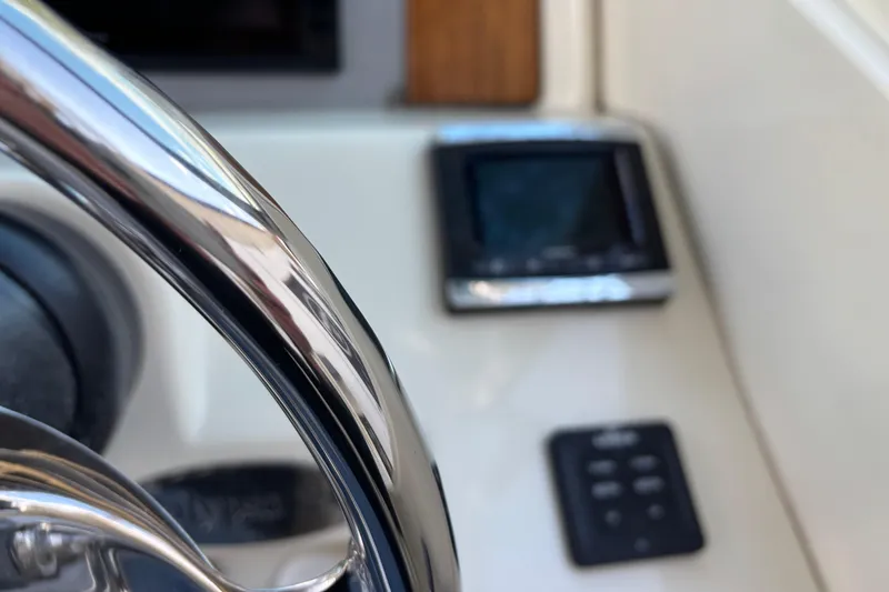 Slide: The Image of Close-up of 2017 Chris-Craft Calypso 26 steering wheel and dashboard controls. - 27