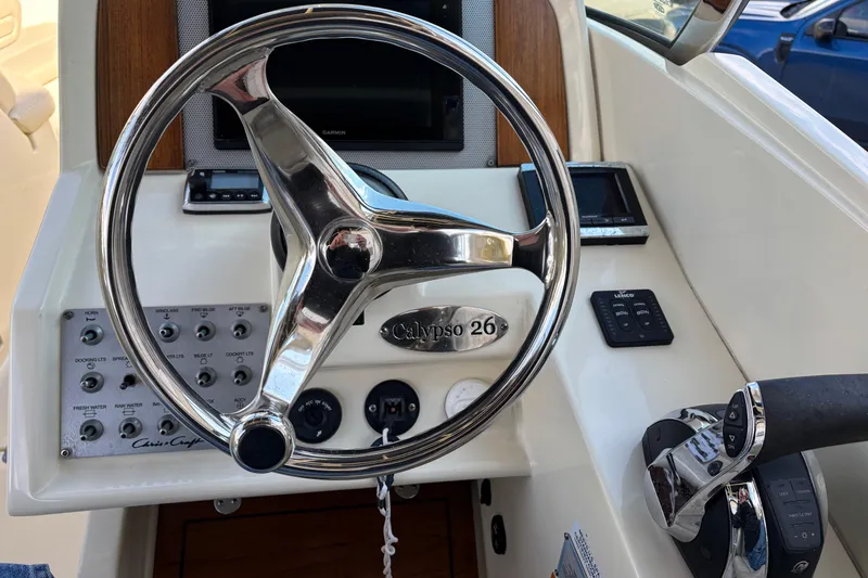 Slide: The Image of Steering wheel and controls of 2017 Chris-Craft Calypso 26 boat cockpit. - 28
