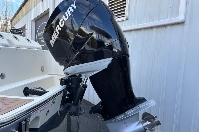 Slide: The Image of 2017 Chris-Craft Calypso 26 with Mercury outboard motor, docked near a building. - 40