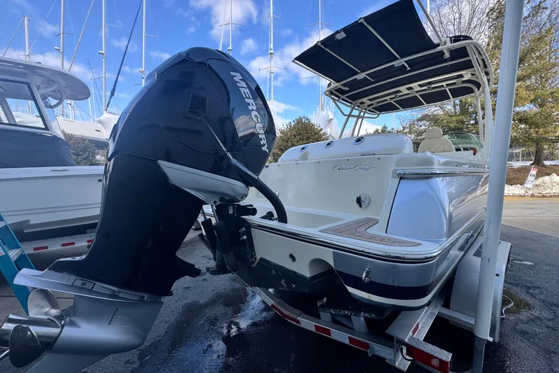Slide: The Image of 2017 Chris-Craft Calypso 26 boat with Mercury outboard motor, docked under blue sky. - 7